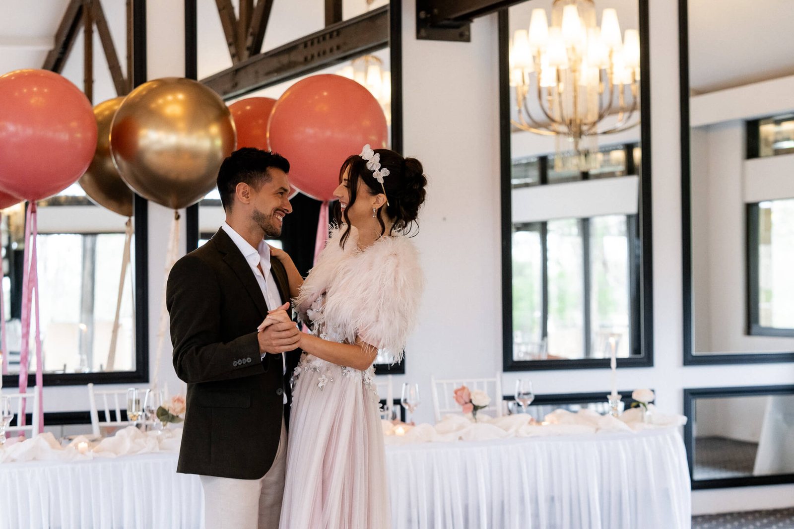 A couple in the Barrington Room, balloons and chandelier