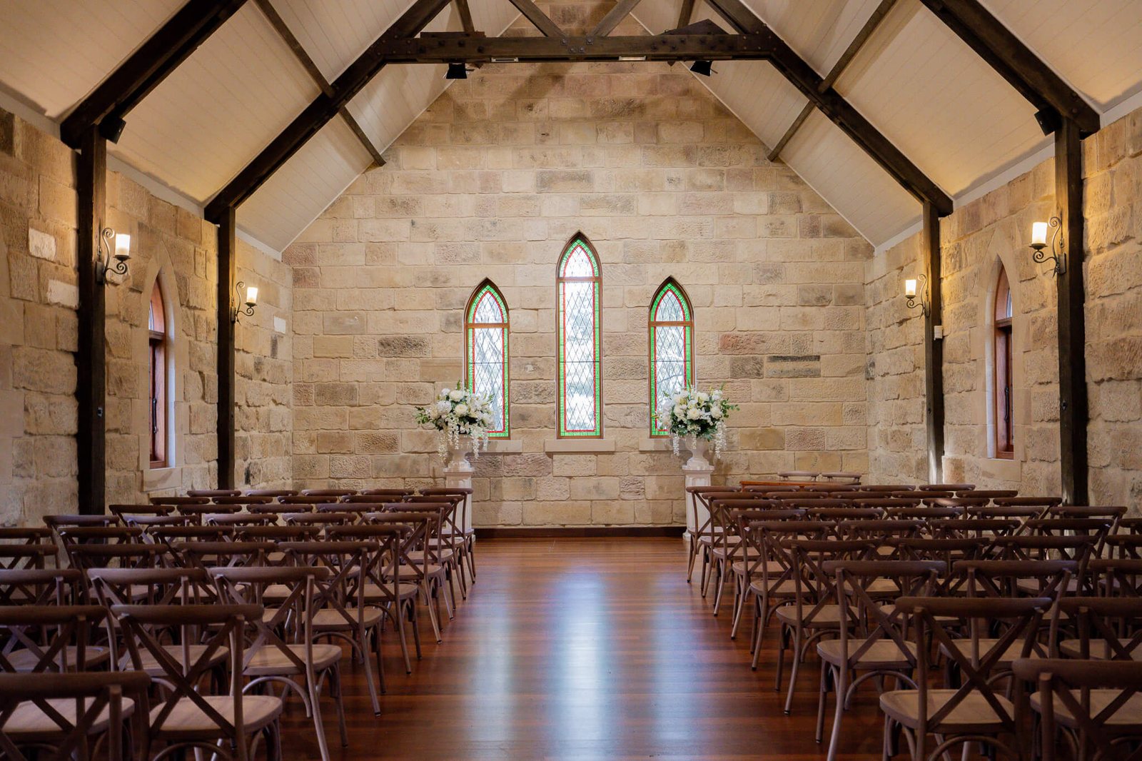 Inside the Carriage House chapel, rows of timber chairs to the altar
