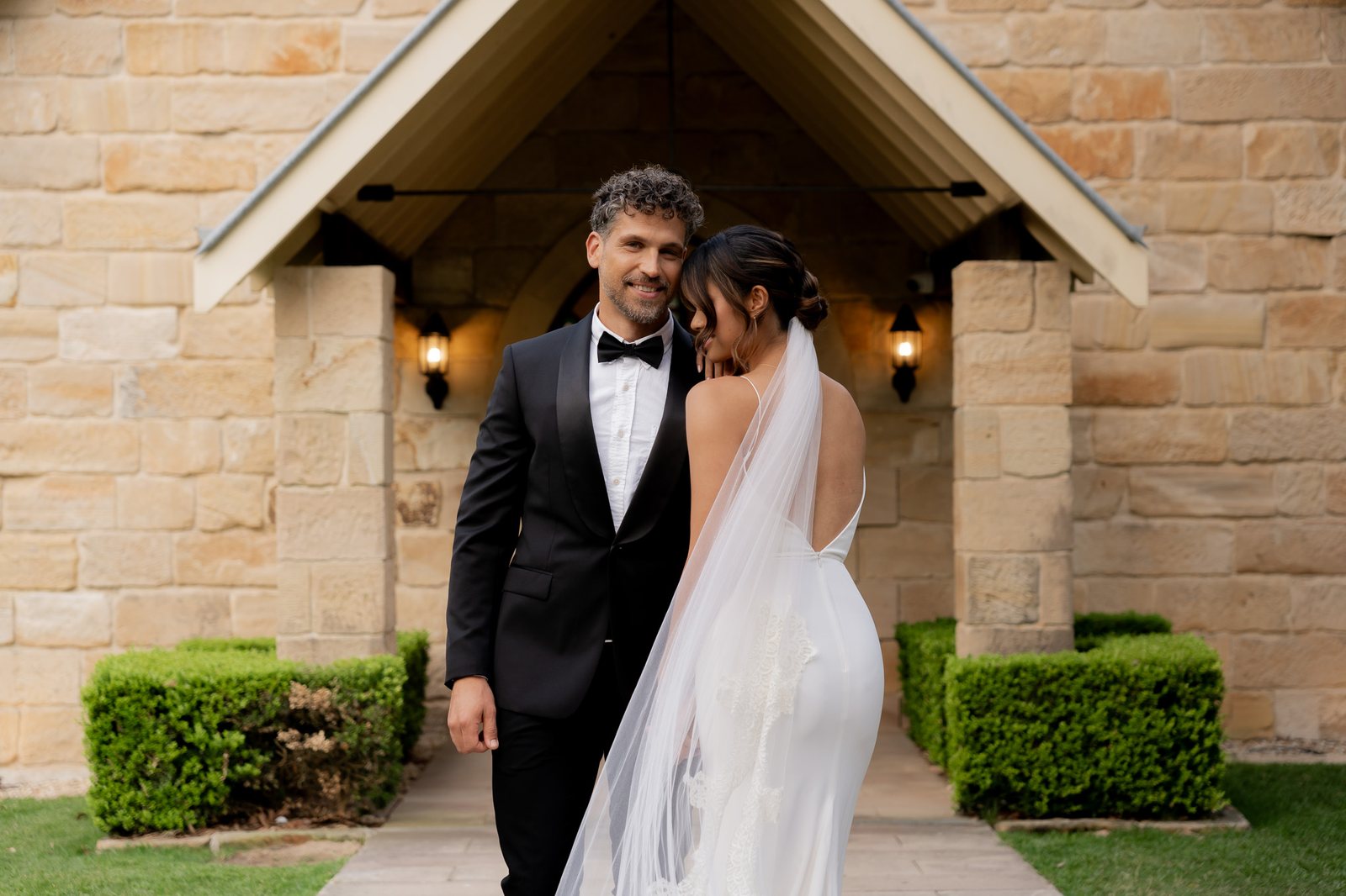 A couple under the sandstone porch of the Carriage House